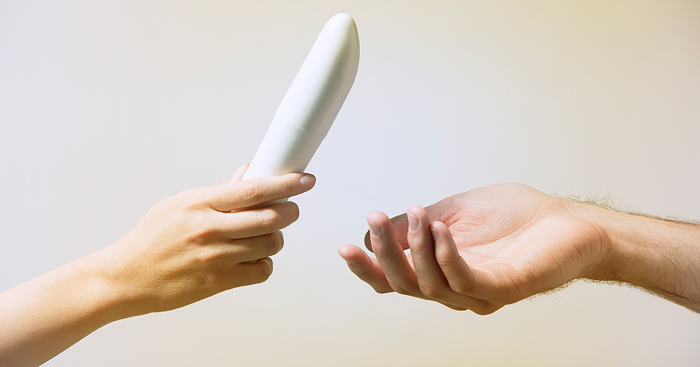 Woman handing man a vibrator