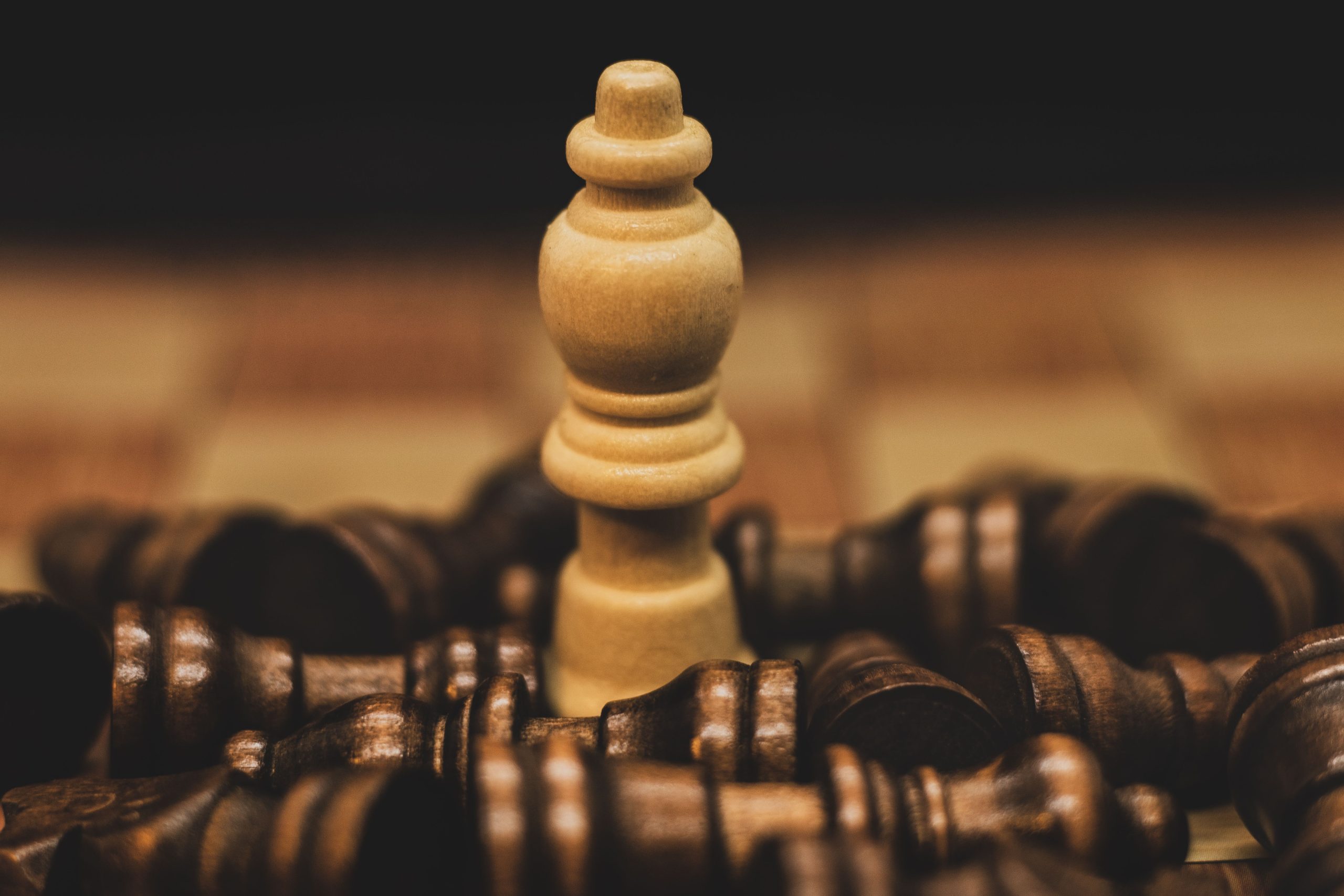 Single chess piece facing a cluster of opposing pieces, symbolizing a small law firm challenging a corporate giant