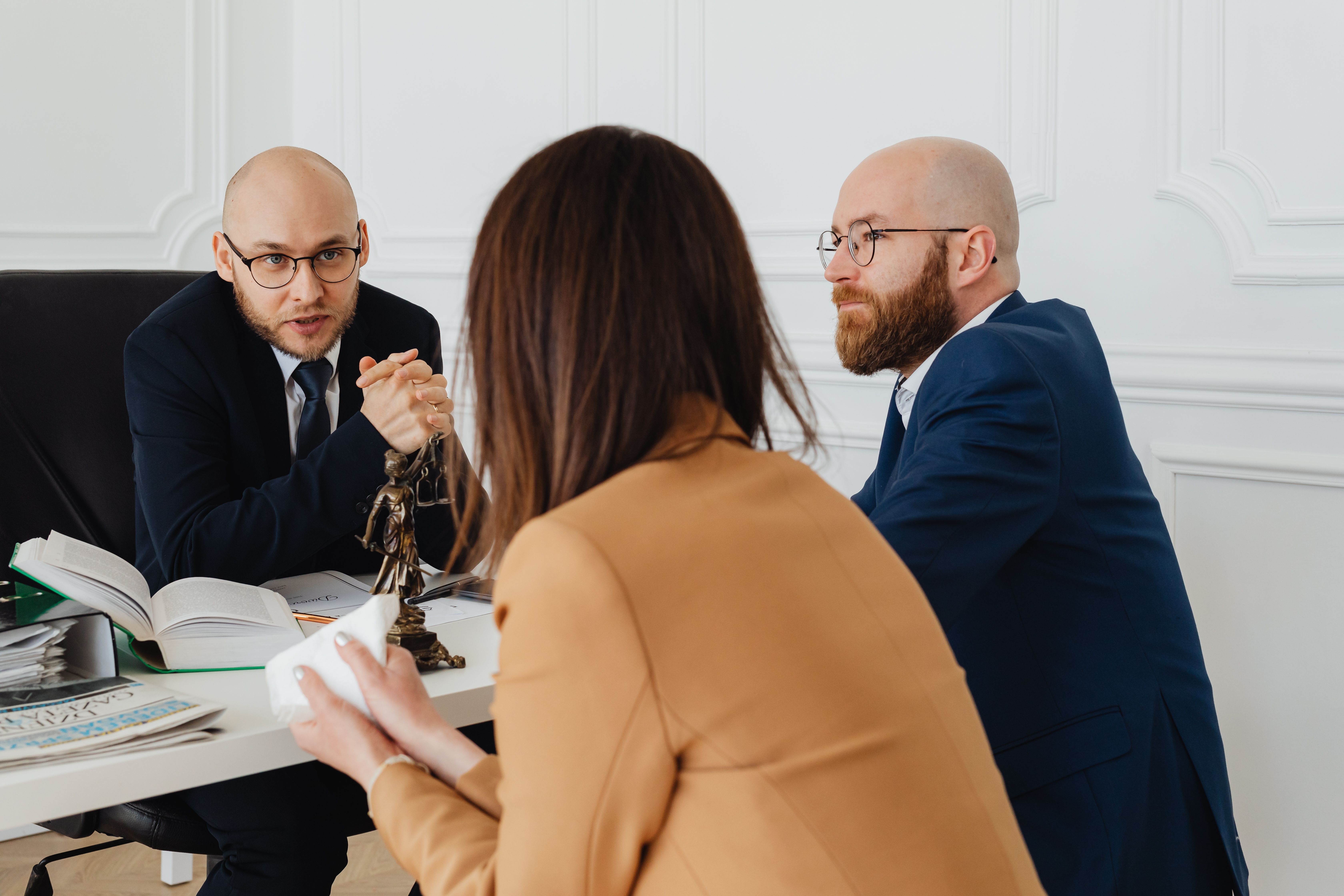 Team of lawyers in discussion at a modern office, strategizing a case against a larger opponent