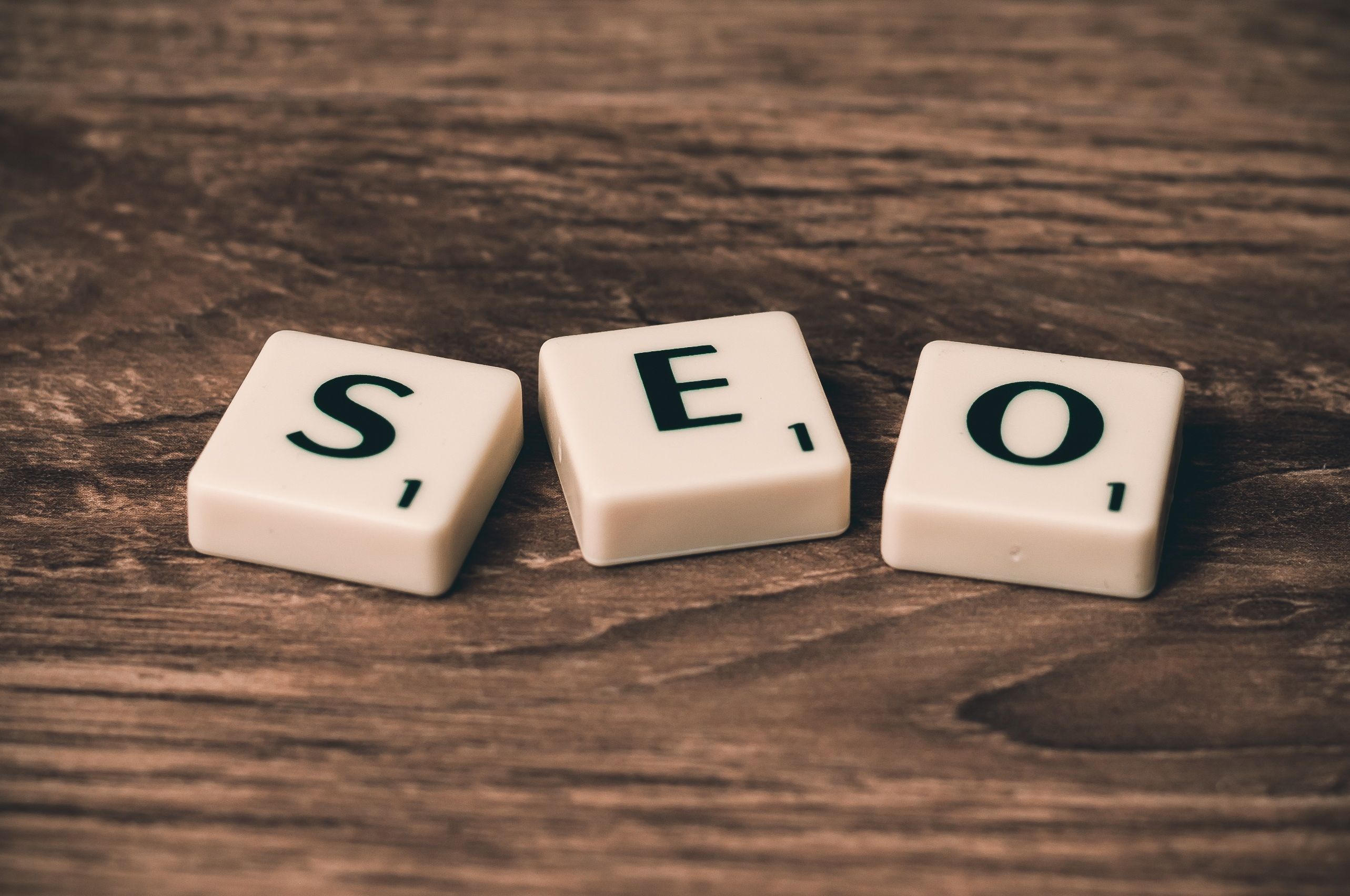 Wooden scrabble tiles spelling SEO on a desk, illustrating search engine optimization for beginners