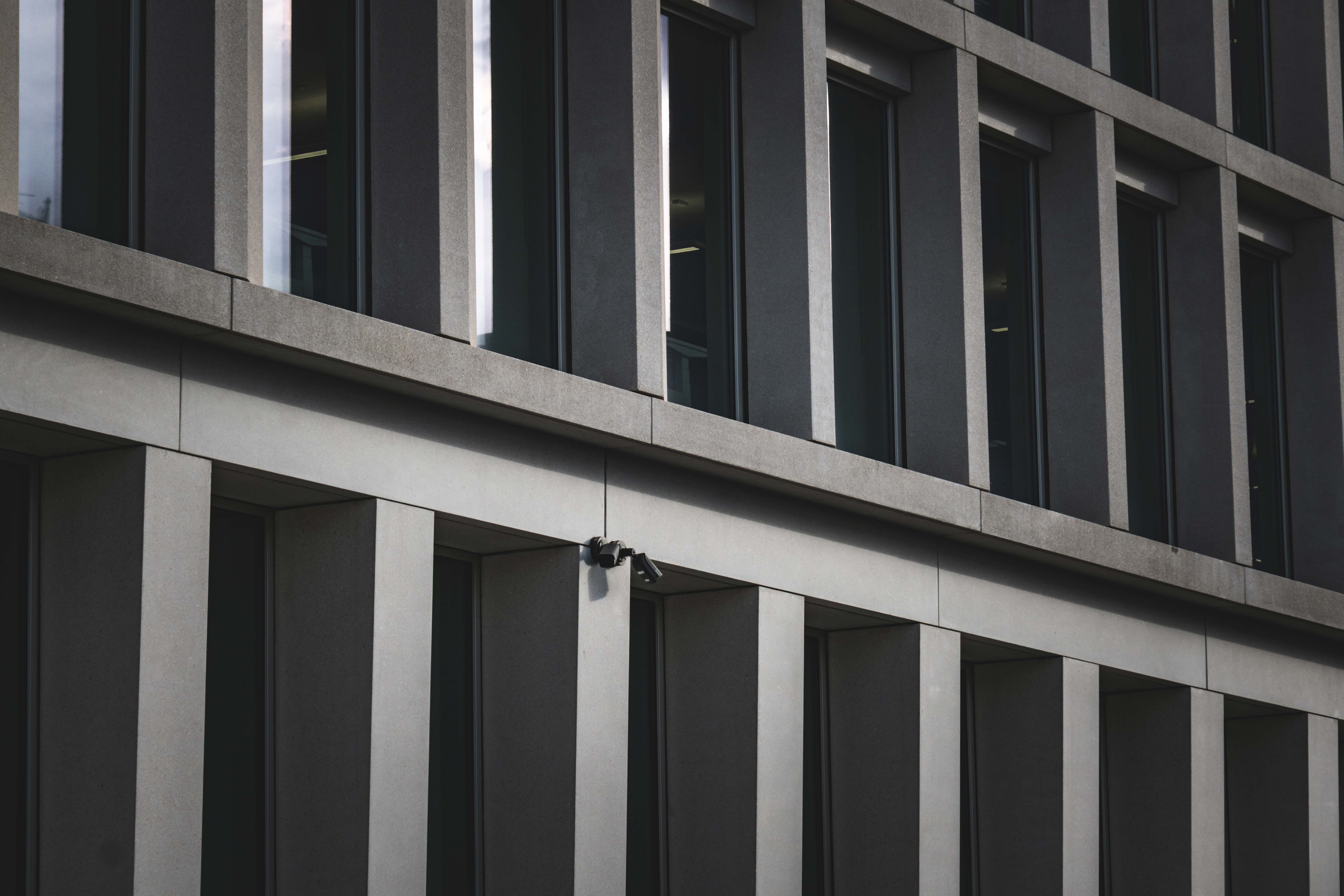 Contemporary office building exterior featuring multiple windows and security cameras.