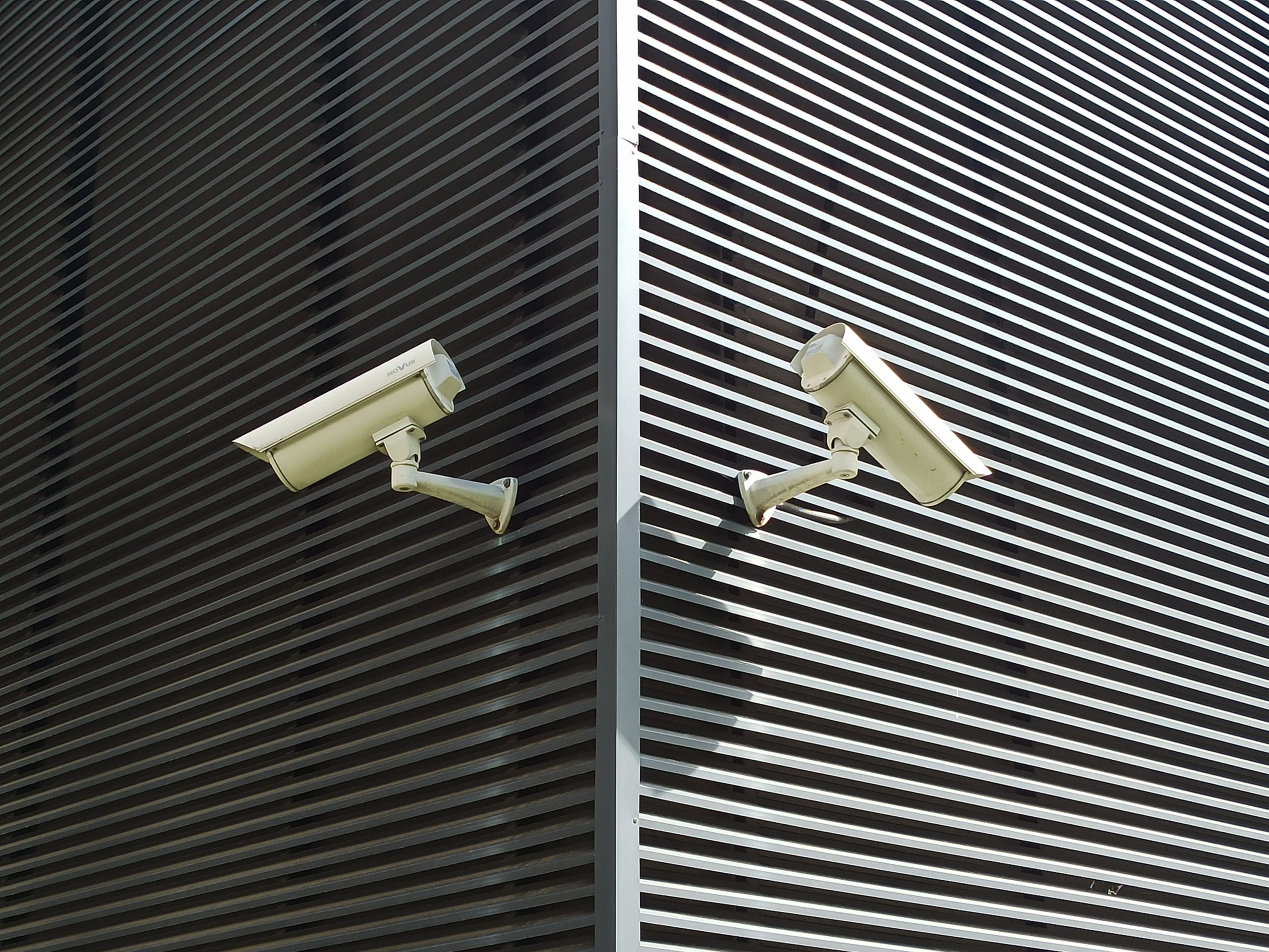Two security cameras mounted on a wall for home surveillance
